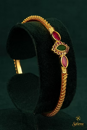 Gold kada with red and green stones